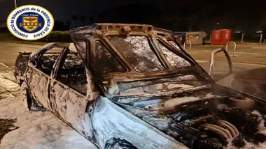 Vehículo totalmente calcinado con restos de espuma usada por los bomberos para sofocar el incendio.