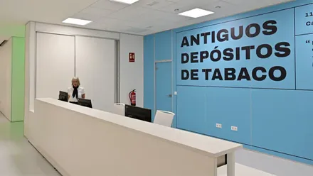 Interior de los Depósitos de Tabaco con el cartel visible y una trabajadora durante la primera tarde de actividad. Foto: Eulogio García.