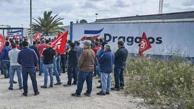 Cola de manifestantes con pancartas rojas y blancas a la entrada de las instalaciones de Dragados.