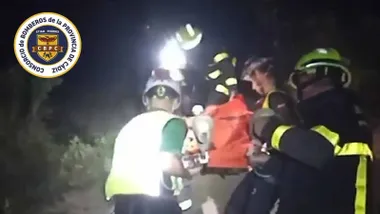 Bomberos evacuan al herido en una camilla roja.