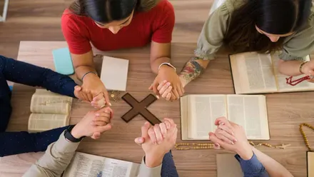 personas evangelistas rezando mientras que se agarran las manos.