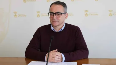 Momento de las explicaciones de Francis Salado, sentado en una mesa, lleva puesto chaleco burdeos y camisa celeste.