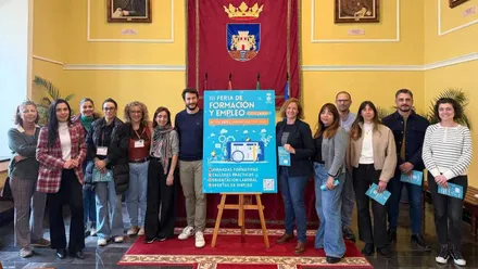 Manuela Pérez y los organizadores junto al cartel de la III Feria del Empleo en Chiclana.