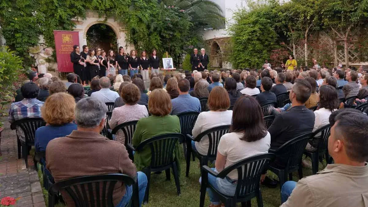 Personas sentadas en un patio viendo una exposición de temas.