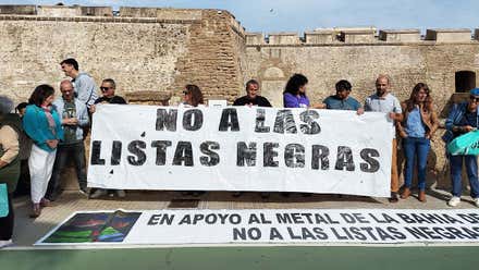 Personas portando una pancarta blanca con letras negras donde se lee: "No a las listas negras".