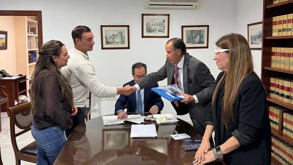 El alcalde estrecha la mano de una pareja que recibe las llaves de su piso.