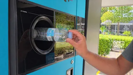 Persona devolviendo envases por reciclaje.