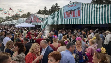 Personas disfrutando en el exterior de una caseta en la Feria del Moscatel de Chipiona.