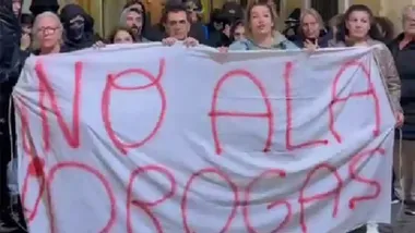 Un grupo de mujeres sujeta una pancarta con el mema "No a las drogas) con otro grupo de personas detrás.