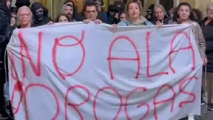 Un grupo de mujeres sujeta una pancarta con el mema "No a las drogas) con otro grupo de personas detrás.