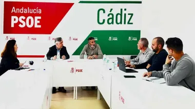 Personas reunidas en una mesa en la sala del PSOE.
