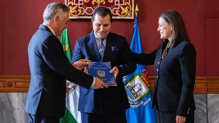 El presidente del Consejo de Hermandades y Cofradías, Eduardo Coto, y la alcaldesa de San Fernando, Patricia Cavada, hacen la entrega a Moisés Posada.