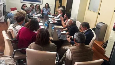 Muchas personas en una mesa sentados y tratando el tema de la vivienda colaborativa como alternativa residencial para las personas mayores.