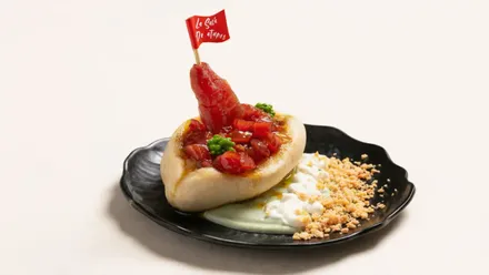 Montadito de atún con verduras y mahonesa y una banderita encima de Sacá.