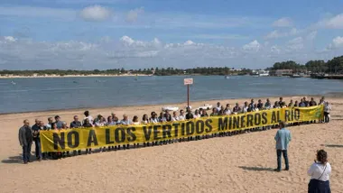 Manifestantes portando una pancarta contra los vertidos en el Guadaliquivir.