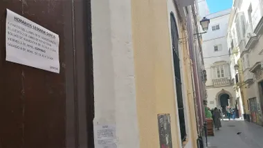 Cartel con el horario de Semana Santa en uno de los comedores sociales de Cádiz.