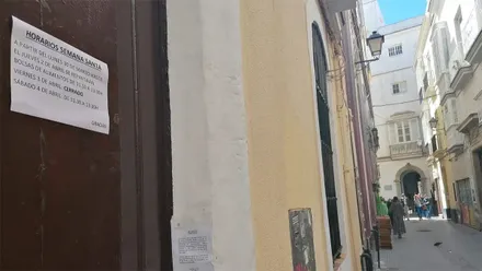 Cartel con el horario de Semana Santa en uno de los comedores sociales de Cádiz.