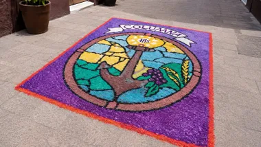 Alfombra en tonos violeta, con un ancla en el centro y la leyenda "Columna".
