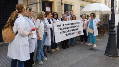 Mujeres del servicio de Ayuda a Domicilio protestan con una pancarta.