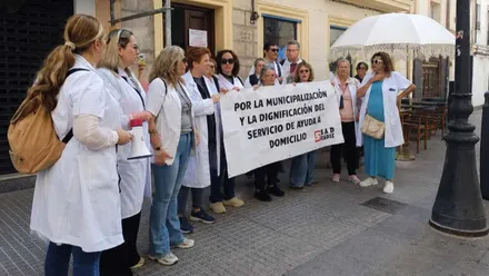 Mujeres del servicio de Ayuda a Domicilio protestan con una pancarta.