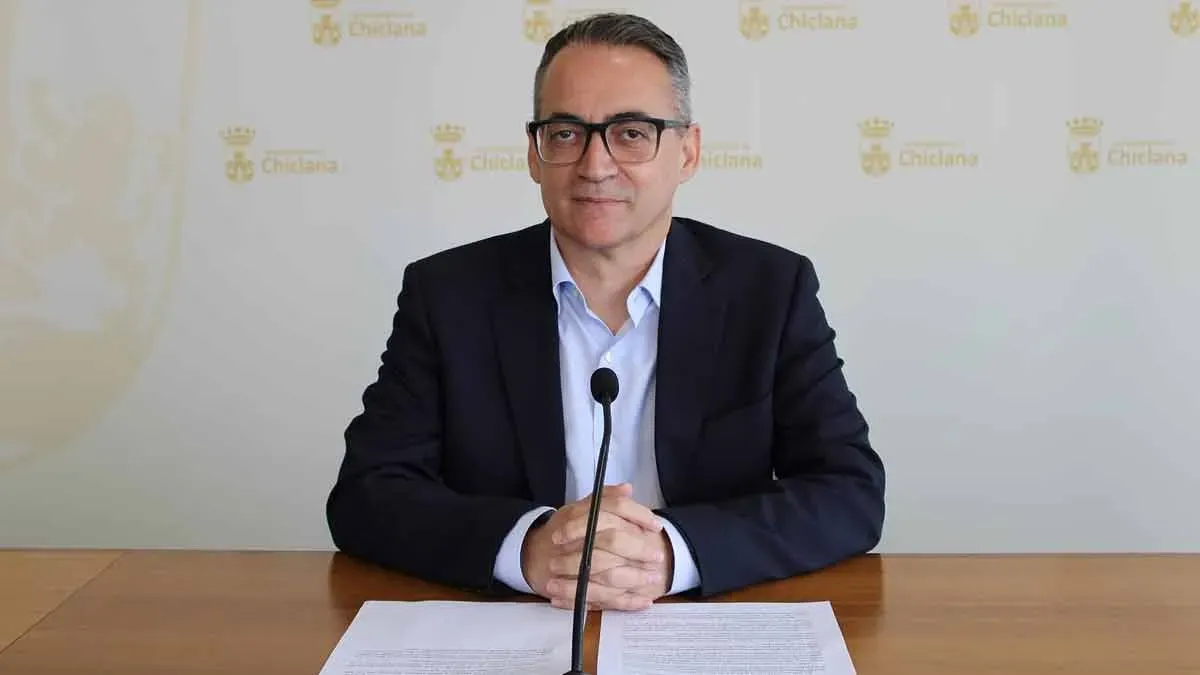 Francis Salado, sentado en una mesa con documentos, son las nuevas ayudas sociales en Chiclana.