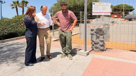 Autoridades municipales, tres personas, mirando la evolución de una obra en la playa de La Barrosa.