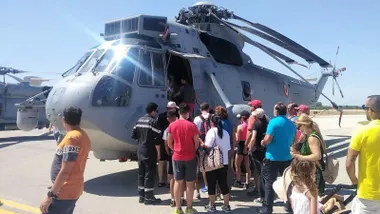 Personas viendo un helicóptero militar en la Base de Rota.