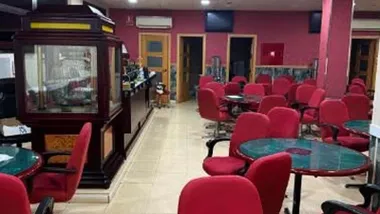 Salón de juegos con sillas tapizadas en burdeos en el bingo ilegal de Barbate.