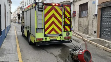 Camión de bomberos en una calle con mangas y una bomba.