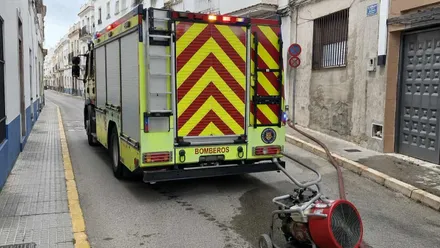 Camión de bomberos en una calle con mangas y una bomba.