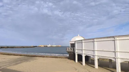 la Caleta con el Balneario de la Palma y el Castillo de San Sebastián en una jornada despejada