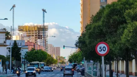 Imagen de la Aveida de la Sanidad Pública de Cádiz con los coches transitando bajo un cielo mayormente despejado