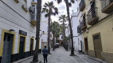 Cielo con nubes y algunos claros en la calle de la Palma de Cádiz con la iglesia del mismo nombre al fondo este lunes 11 de mayo. Foto: José Luis Porquicho Prada.