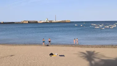 Cuatro personas se bañan en la playa de la Caleta a primera hora de la mañana tras la segunda noche tropical consecutiva en Cádiz.