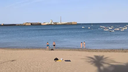 Cuatro personas se bañan en la playa de la Caleta a primera hora de la mañana tras la segunda noche tropical consecutiva en Cádiz.