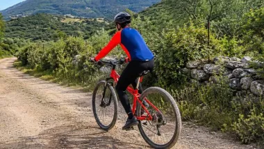 Hombre en su bicicleta por un camino rural de la Sierra de Cádiz.