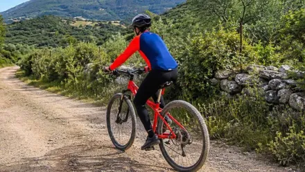 Hombre en su bicicleta por un camino rural de la Sierra de Cádiz.