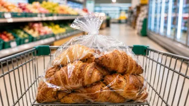 Bolsa con cruasanes del Hacendado por la calle del supermercado.