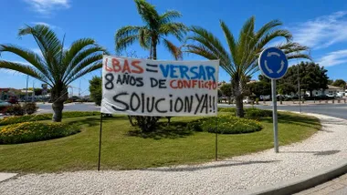 Pancarta con pintura en azul, rojo y rejo, protestando por la situación laboral en la Base de Rota.