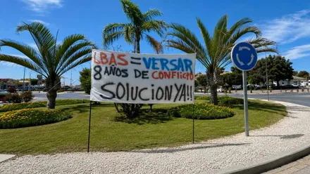 Pancarta con pintura en azul, rojo y rejo, protestando por la situación laboral en la Base de Rota.