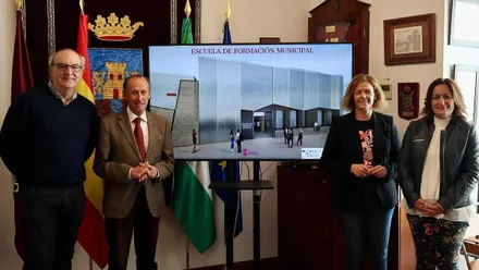 Autoridades locales de Chiclana posando junto a una pantalla con la Escuela Municipal de Formación.