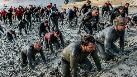 Corredores cubiertos de barro en una playa.