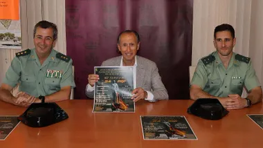 En una mesa el alcalde de Chiclana y dos guardias civiles presentando el cartel del homenaje en Chiclana.
