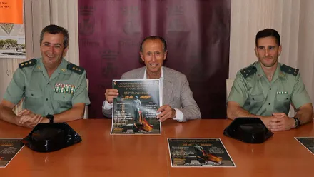 En una mesa el alcalde de Chiclana y dos guardias civiles presentando el cartel del homenaje en Chiclana.