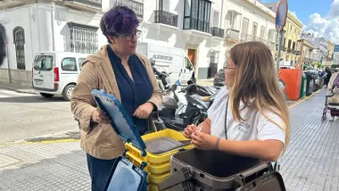 Dos mujeres junto a contenedores de residuos en una calle de Sanlúcar.