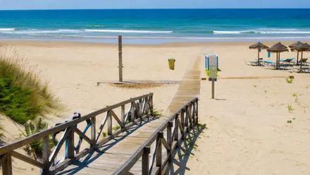 Vista del acceso de madera a La Barrosa y orilla de la playa.