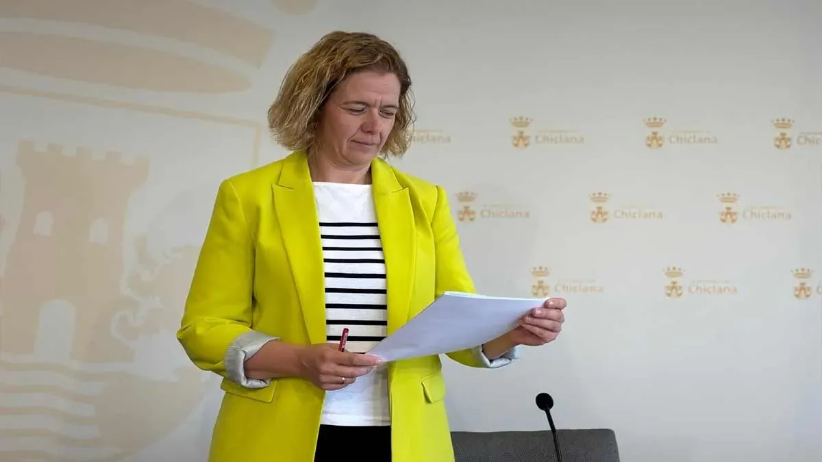 Manuela Pérez, con chaqueta amarilla leyendo un folio.