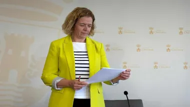 Manuela Pérez, con chaqueta amarilla leyendo un folio.