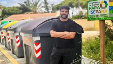 Contenedores de reciclaje, delante de ellos, con camiseta negra, Roberto Palmero.