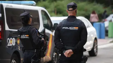 Dos agentes de la Policía Nacional junto aun vehículo. La mujer porta un fusil de asalto.